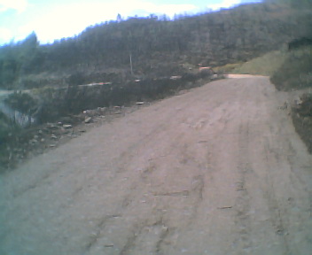 Estrada envolvente de terra batida que passa por fora da povoao do Monte Frio na Segunda-feira, 22 de Maio de 2006