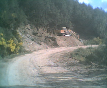Estrada envolvente de terra batida que passa por fora da povoao do Monte Frio na Segunda-feira, 22 de Maio de 2006